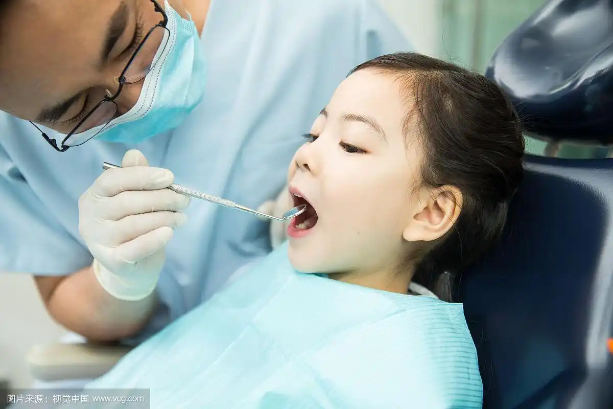 男牙医在为小女孩检查牙齿