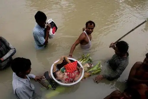 优秀奖 人们运送在洪水中被打捞上来的无人认领的小孩遗体.