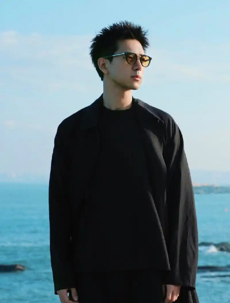 李现晒近照,寸头变长了气质好man,一身黑衣在海边耍帅气场十足.