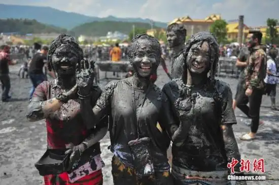当日,中外游客汇聚于云南省沧源佤族自治县共度"摸你黑"狂欢节,人们用