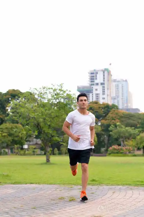 年轻英俊的西班牙裔男子在公园慢跑的全身照片