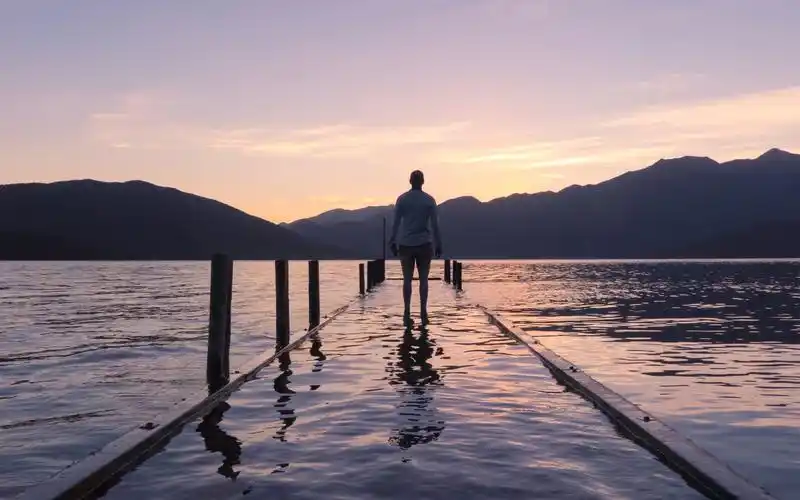 一个人在海边看着日出日落