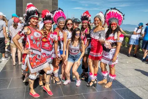 耶稣雕像下的穿着民族特色服装的印第安人与游客们合影.