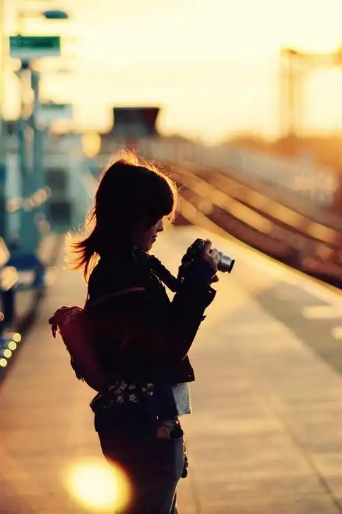 小女孩使用相机,火车站,日落 iphone 壁纸