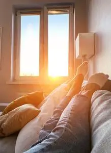 穿着白袜子的年轻女子躺在家里的沙发上两双带有黄色