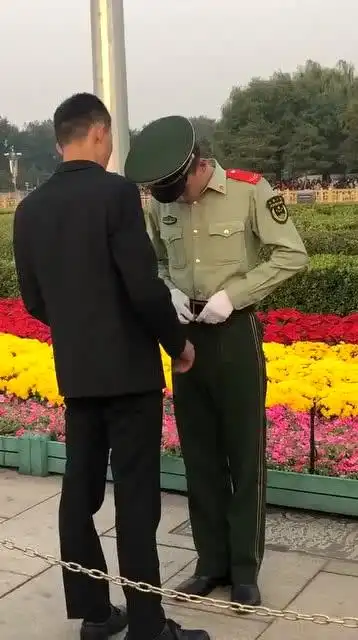 天安门广场发生的一幕,黑衣人竟然指导兵哥哥整理军装!