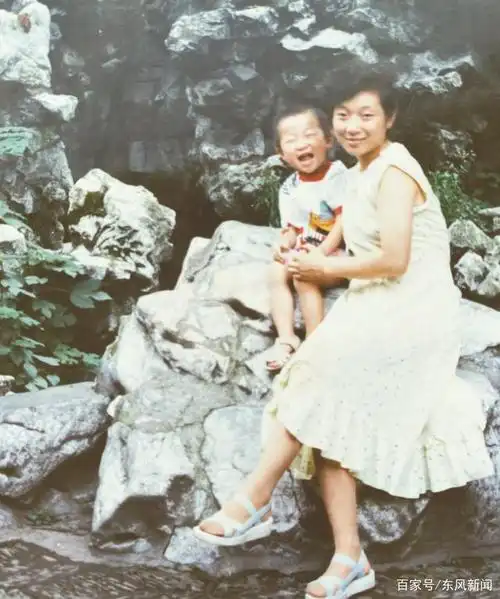 儿时的李飞在母亲怀里开怀大笑