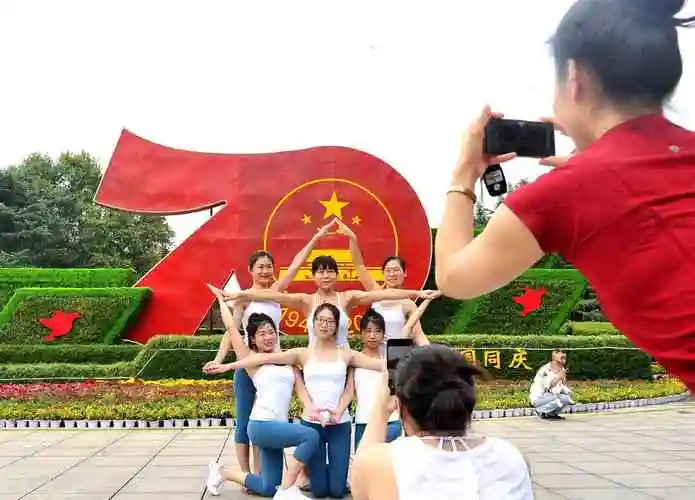 烈士公园内,市民在景观造型前摆出五角星的造型合影留念.