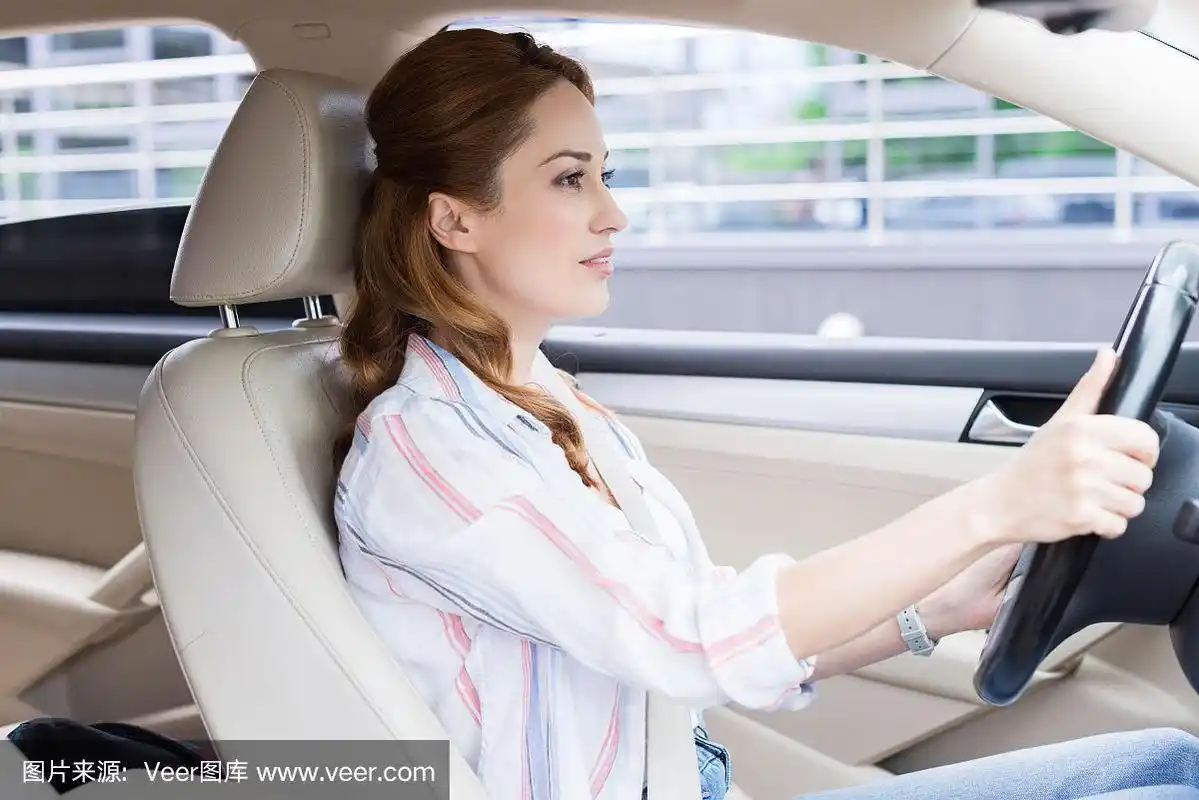 有魅力的女人独自开车的侧视图