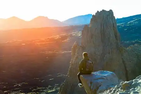 穿着运动服的无畏的人坐在悬崖边. 抽象过过滤.