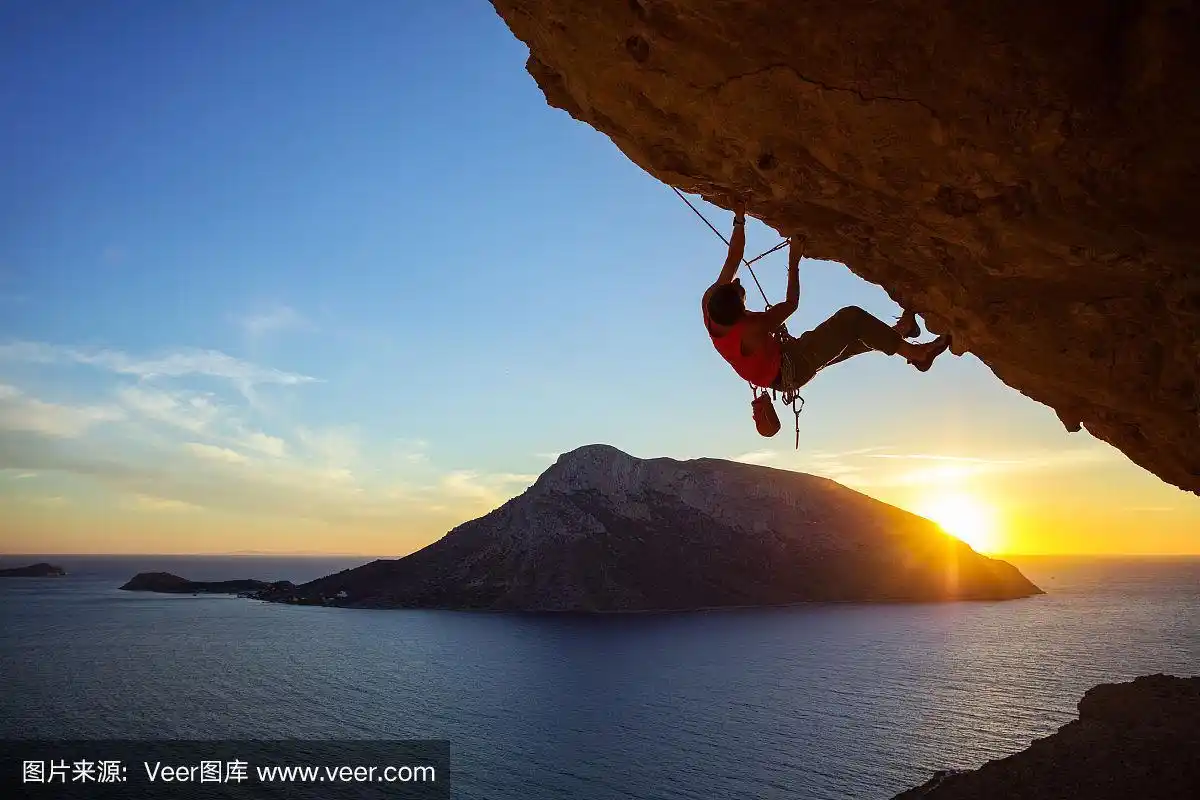 日落时分,一个年轻人在攀登悬崖峭壁