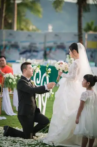 新郎和新娘在碧海蓝天下交换戒指,互许珍爱彼此的诺言.