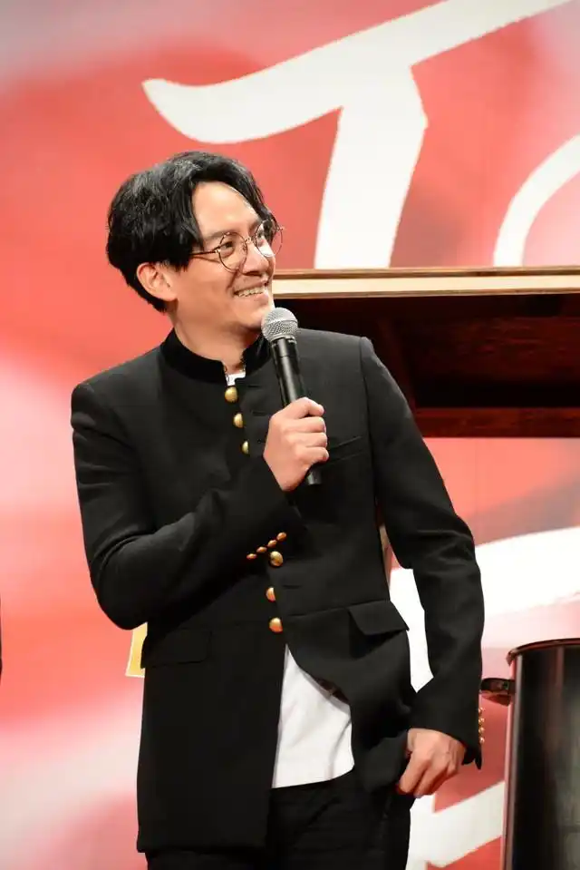 张震黑衣黑裤脚踏白球鞋简约帅气,梳中分发型戴眼镜儒雅十足