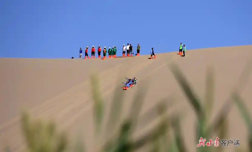 2022年6月3日,敦煌市鸣沙山月牙泉景区组织开展滑沙听雷,沙漠鳞舟