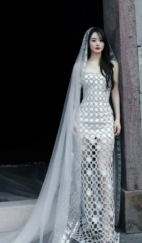 相比于第一套造型,我更喜欢赵丽颖的第二套白色抹胸镂空高定礼服,镂空