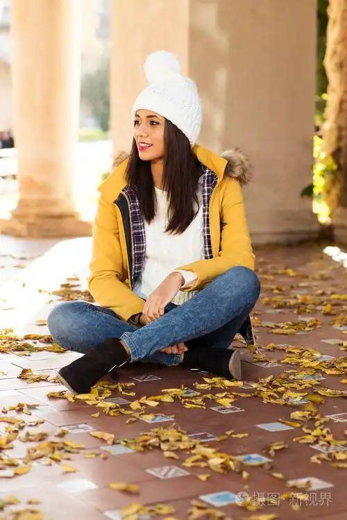 美好的幸福女人坐在树叶秋天的生活观