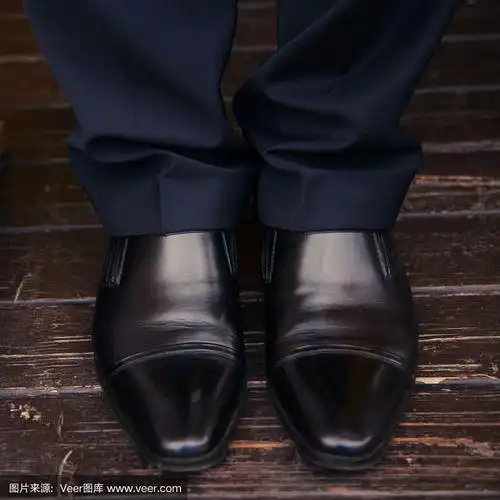 男人的腿在地板上穿鞋