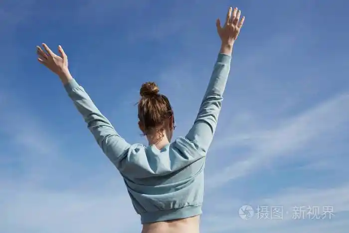 年轻女孩传播喜悦与启示面对太阳的手