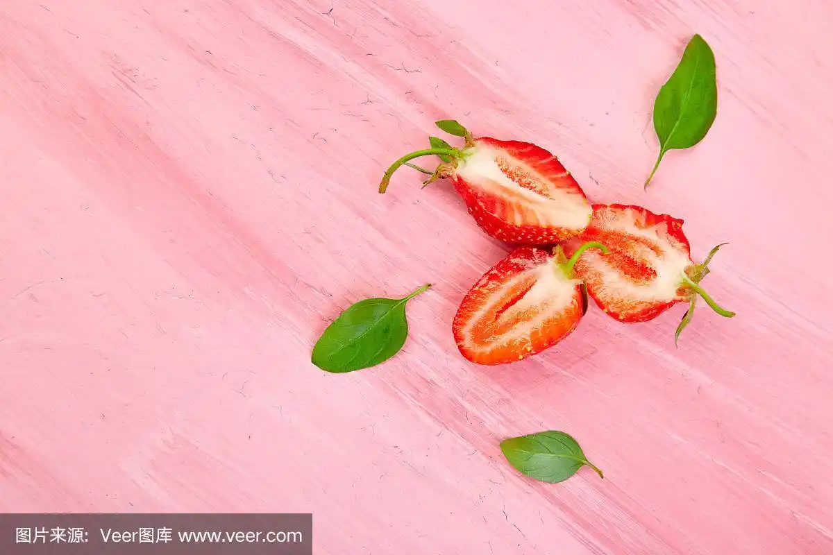 粉色背景上放草莓和罗勒.水果框架.