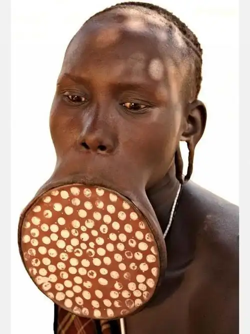 女性成人礼这名河部落长老的造型相当独特,穿着湖绿色西装,嘴巴和耳朵