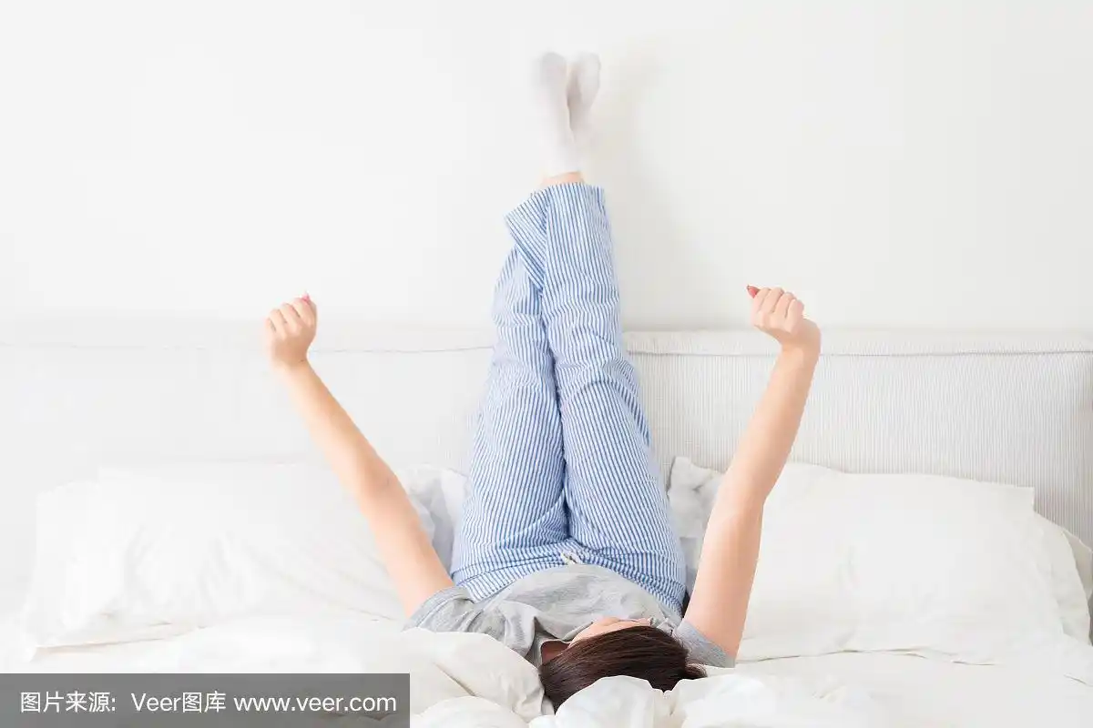 卧室里,女孩翘着腿躺在床上