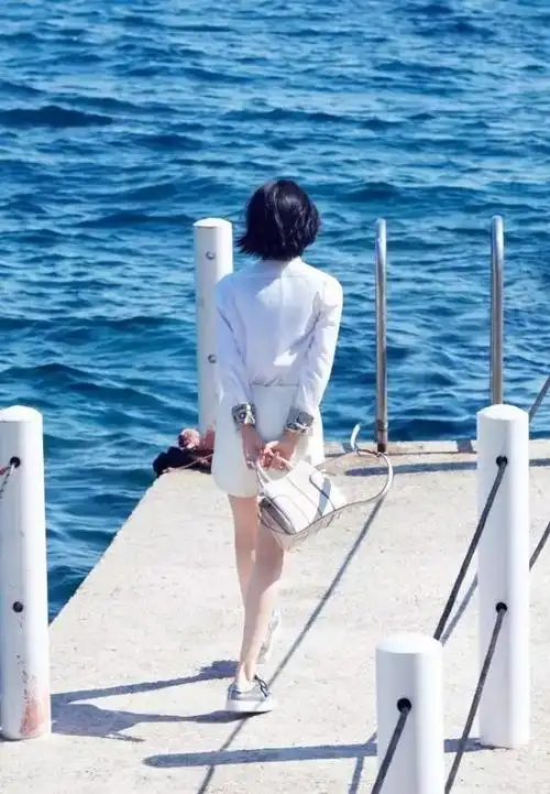 白衬衫搭配白裙,和海景融为一体,光是一个背影就已经美得引起人无限