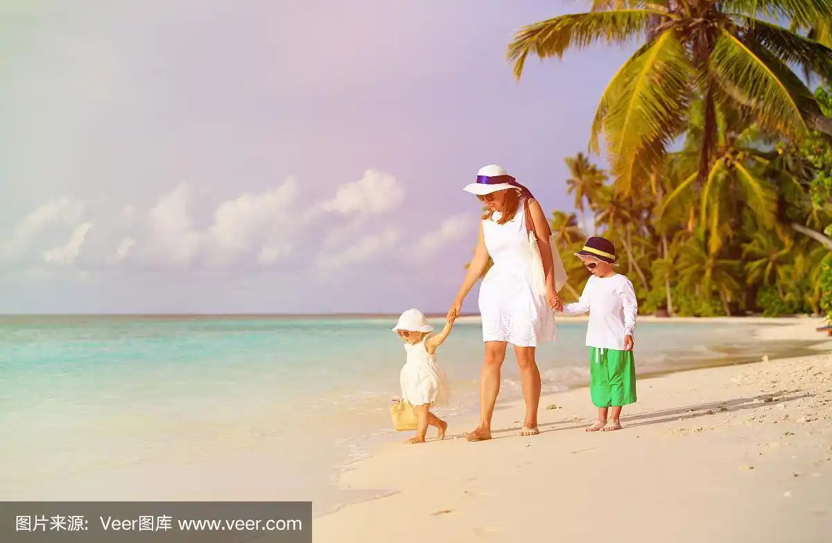 母亲和两个孩子在热带海滩上散步