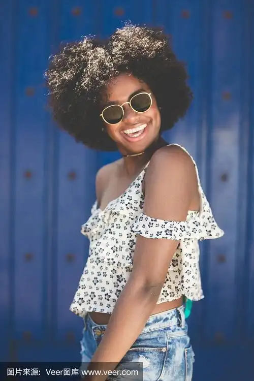 年轻漂亮的美国黑人女人戴着太阳镜笑