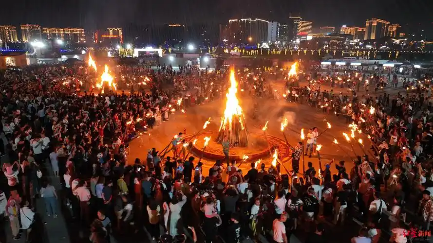西昌点燃第八届凉山彝族火把节西昌火把月活动第一把火千人围篝火跳达