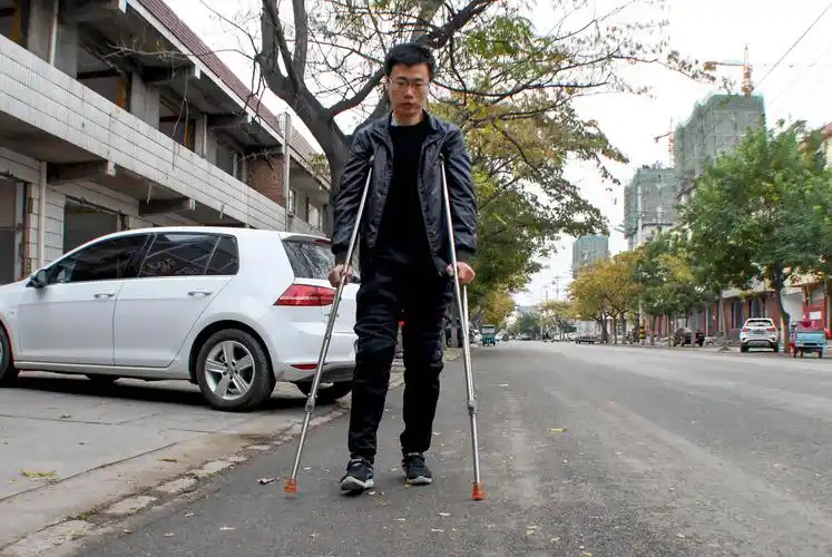 闫英华拄着双拐,行动不便.