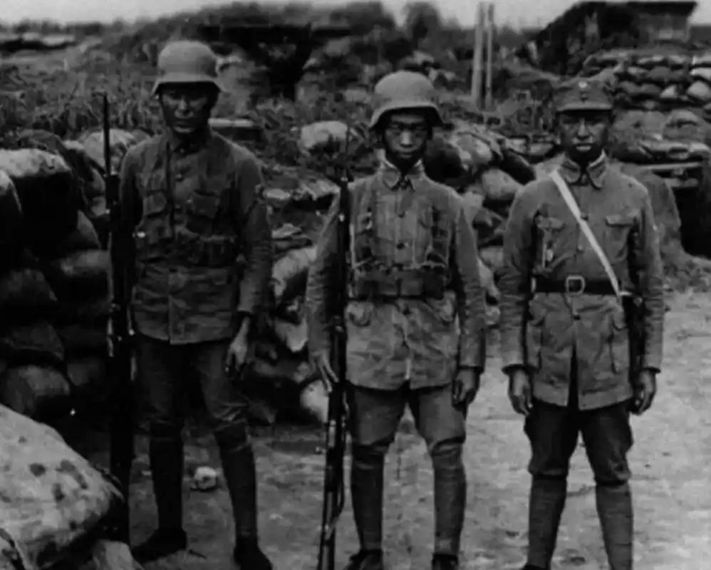 从照片中可见,他们身穿军服,头戴钢盔,腰间别着皮质子弹带,手里拿着