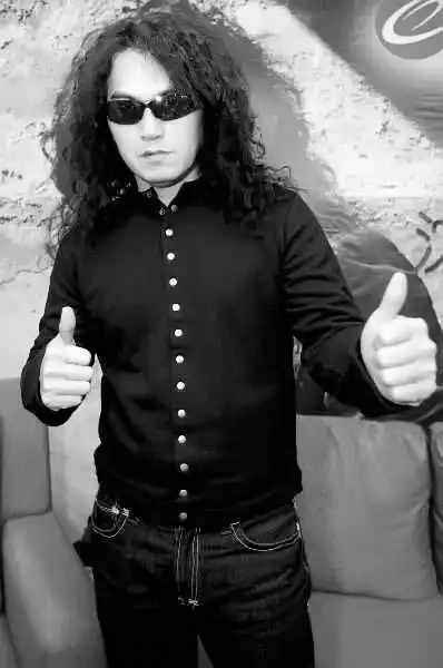 随着音乐节奏甩着长卷发,用沙哑的歌声让全场沸腾的迪克牛仔(听歌