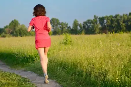 在户外,小路上慢跑的女跑步运动员春天跑步和锻炼照片