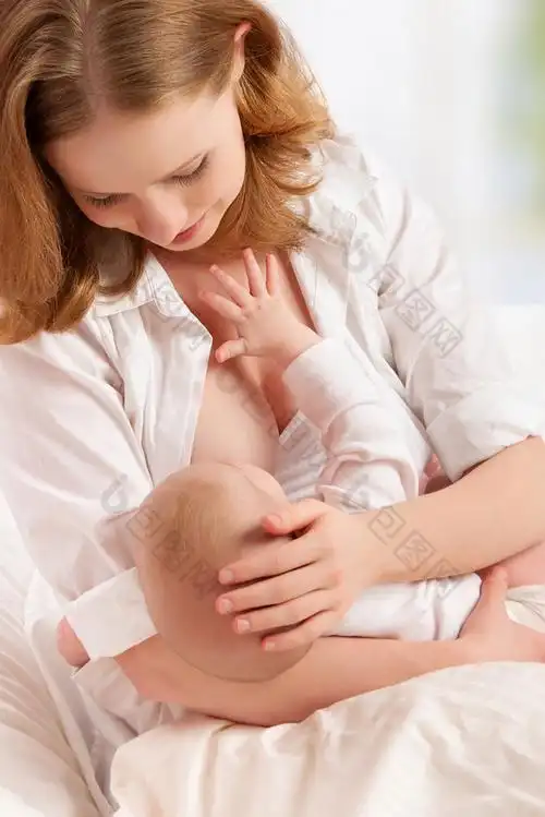 母亲喂母乳她躺在床上的婴儿