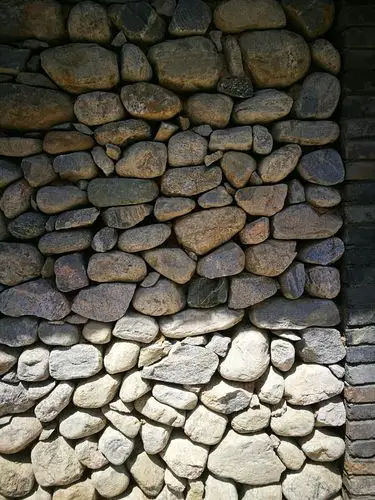 用鹅卵石砌墙真不容易,乱而平整.