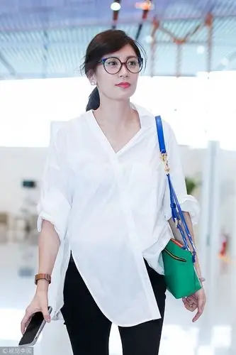 逆龄女神贾静雯现身机场白衬衫清新干练