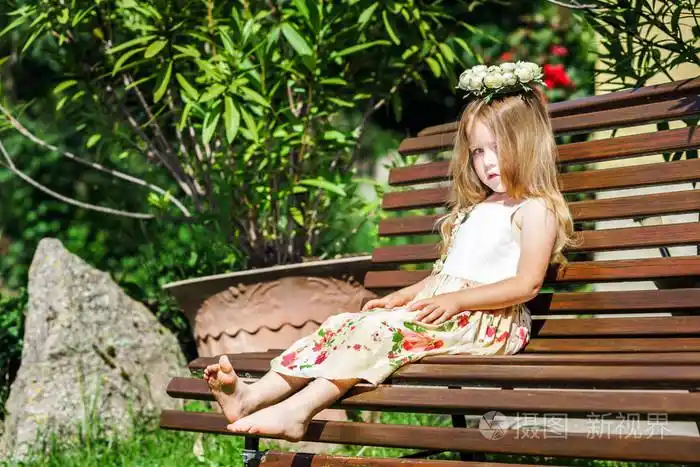 可爱的利特尔光脚妞坐在板凳上