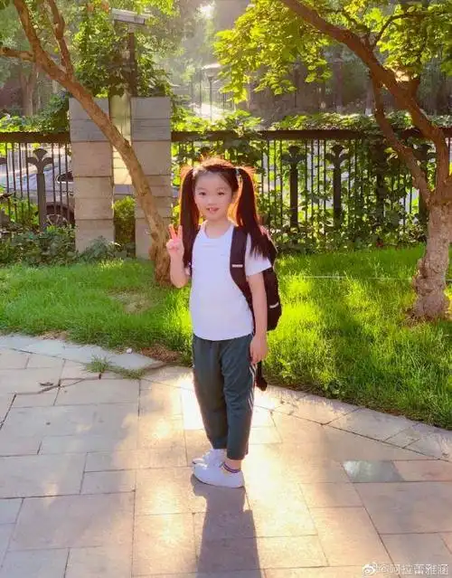 在这组照片中,阿拉蕾依然扎着两个可爱的马尾,穿着一件白色运动衣和