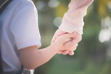 亚洲母亲牵着小儿子的手在户外背包, 回到学校照片