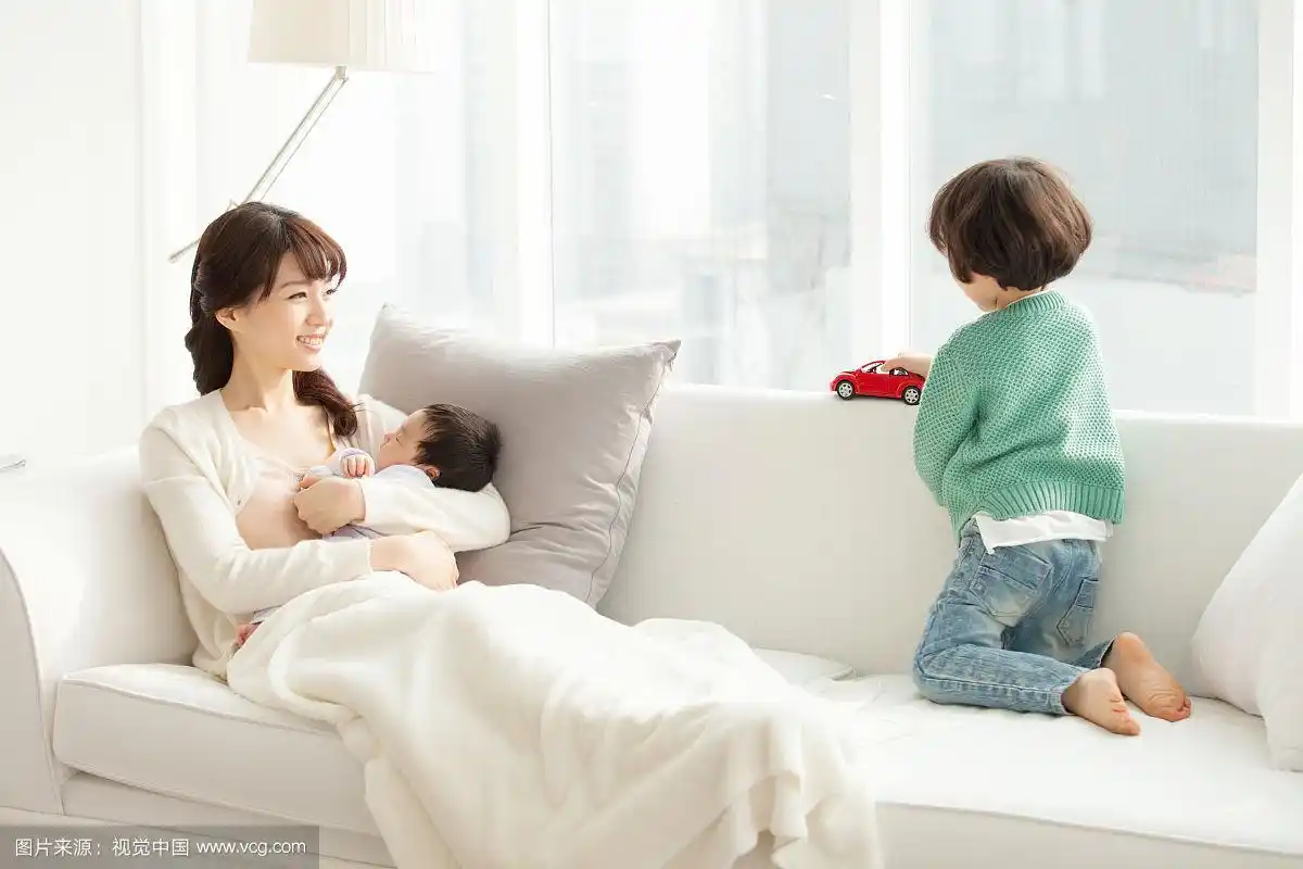 妈妈抱着宝宝玩玩具,坐在沙发上和男孩子们一起玩