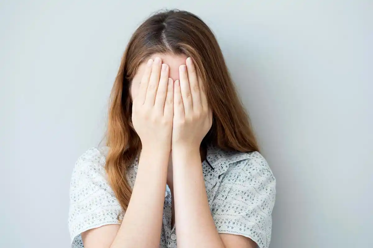 害羞的女孩捂住她的脸