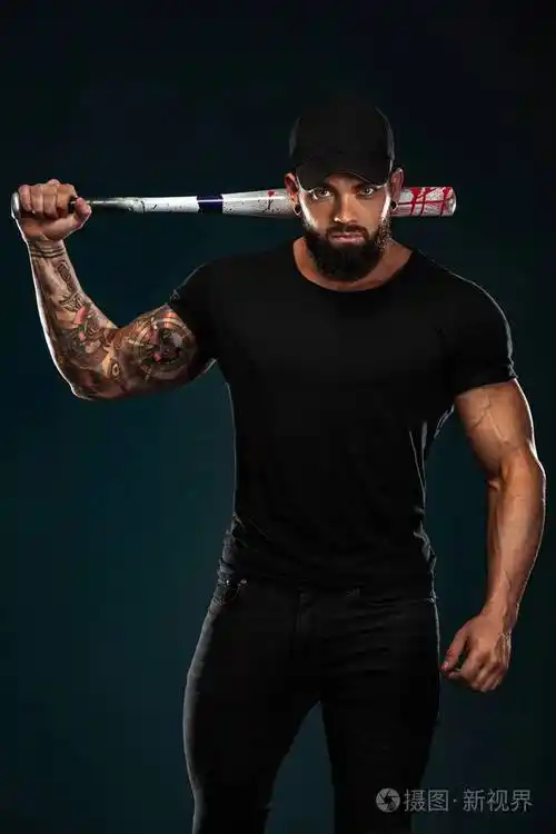 强壮和健康的男子健美运动员与棒球棒在黑色t恤.运动型肌肉男运动员.