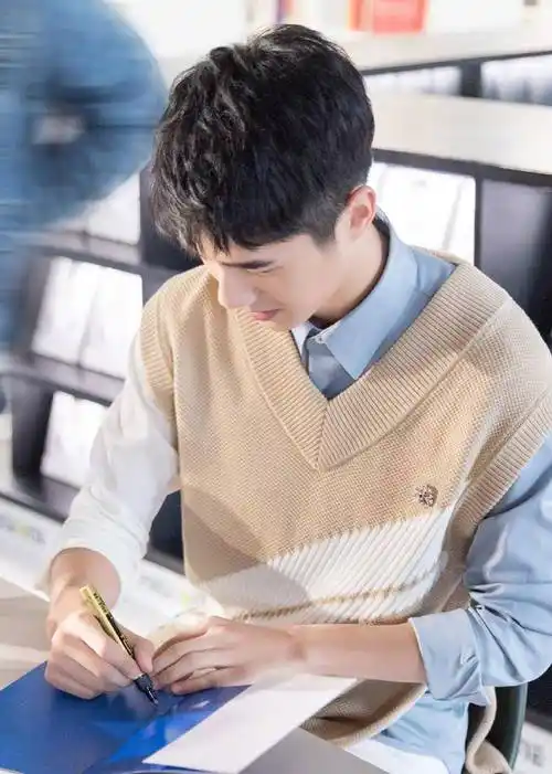 签名会上,刘昊然身穿蓝色衬衫搭配英伦绅士感满满的针织背心,还特意剪
