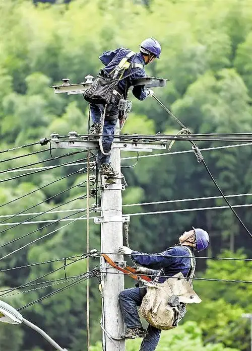4月25日,电力工人在电线杆上进行连线作业.