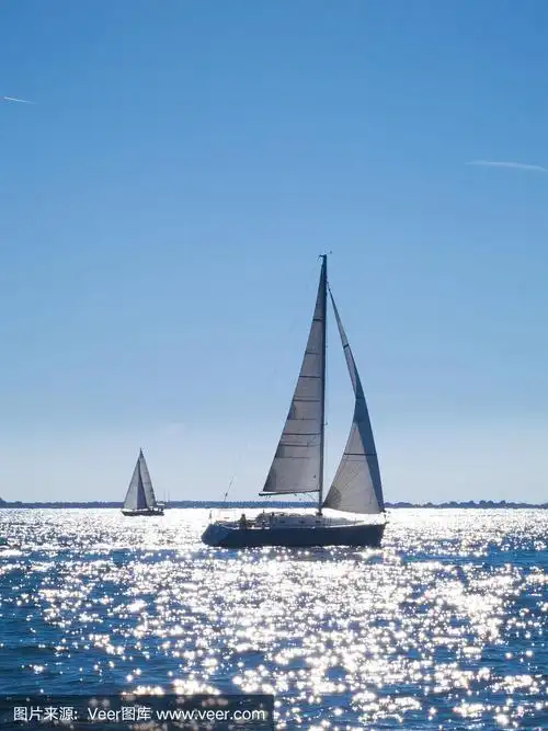 在夏日的阳光反射下,帆船在海上航行