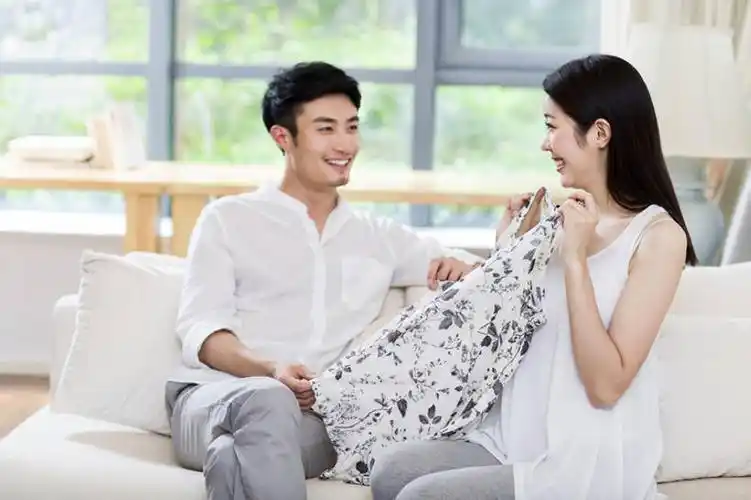 年轻情侣在客厅看一件女式衣服