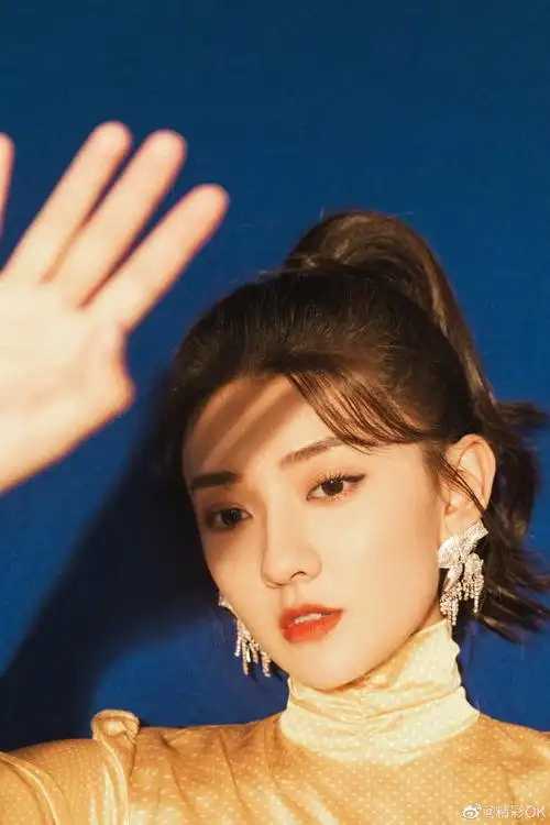 梁洁俏皮马尾金色心形露背连衣裙搭配蝴蝶结闪钻耳饰灵动可爱