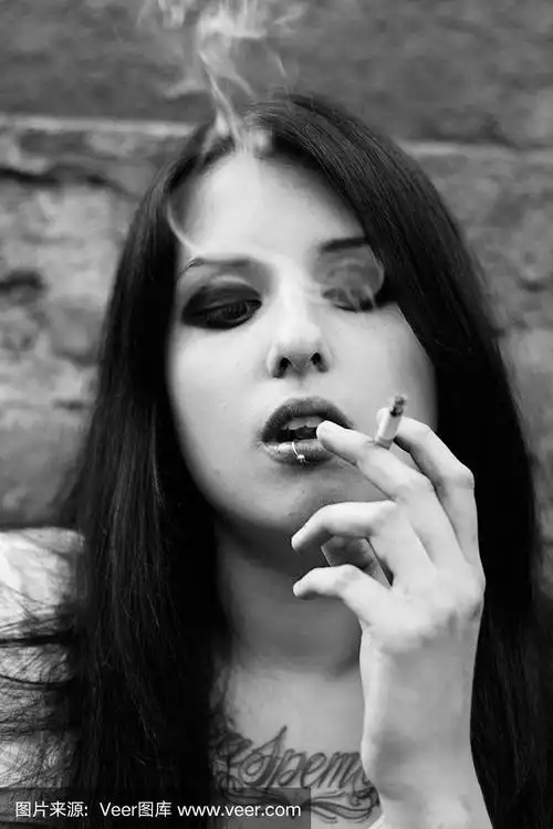 有纹身的漂亮女孩正在抽烟