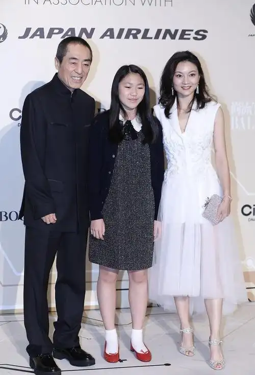 张艺谋妻子挺娇嫩的,白色卫衣配红色短裙,看不出是40多岁的人