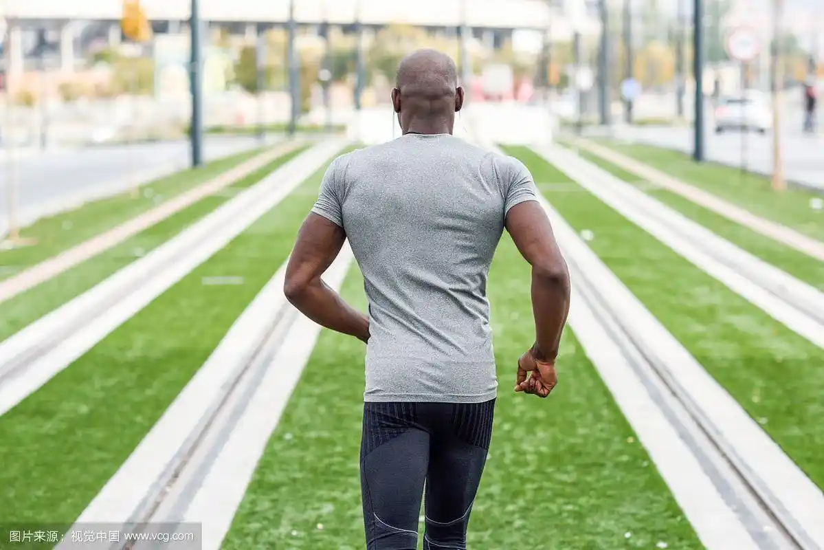 黑人在城市背景下奔跑的背影.男性在户外锻炼.
